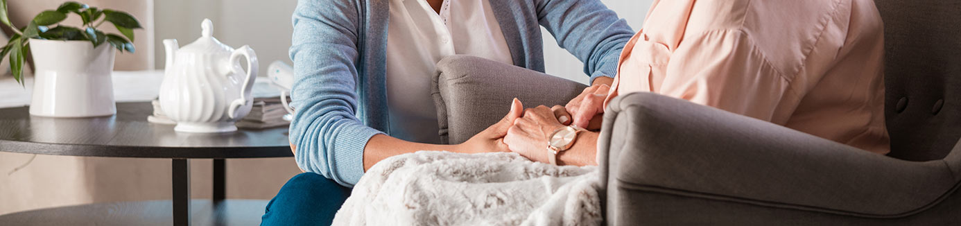Caregiver holding patient's hands