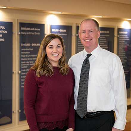 Karli and Jonathan in front of donor wall