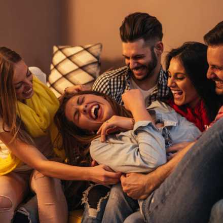 group of Friends tickling their friend in the middle