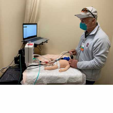 Doctor practicing with Neonatal Resuscitation Device on doll