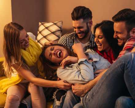 group of Friends tickling their friend in the middle