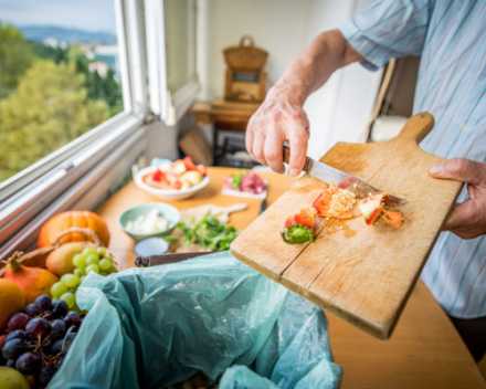 cutting board with veggies and man holding a knife