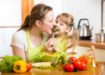 mother and daughter eating vegetables