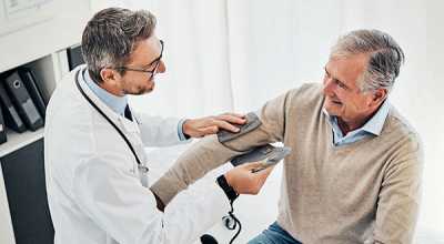 Doctor checking a male patient's blood pressure