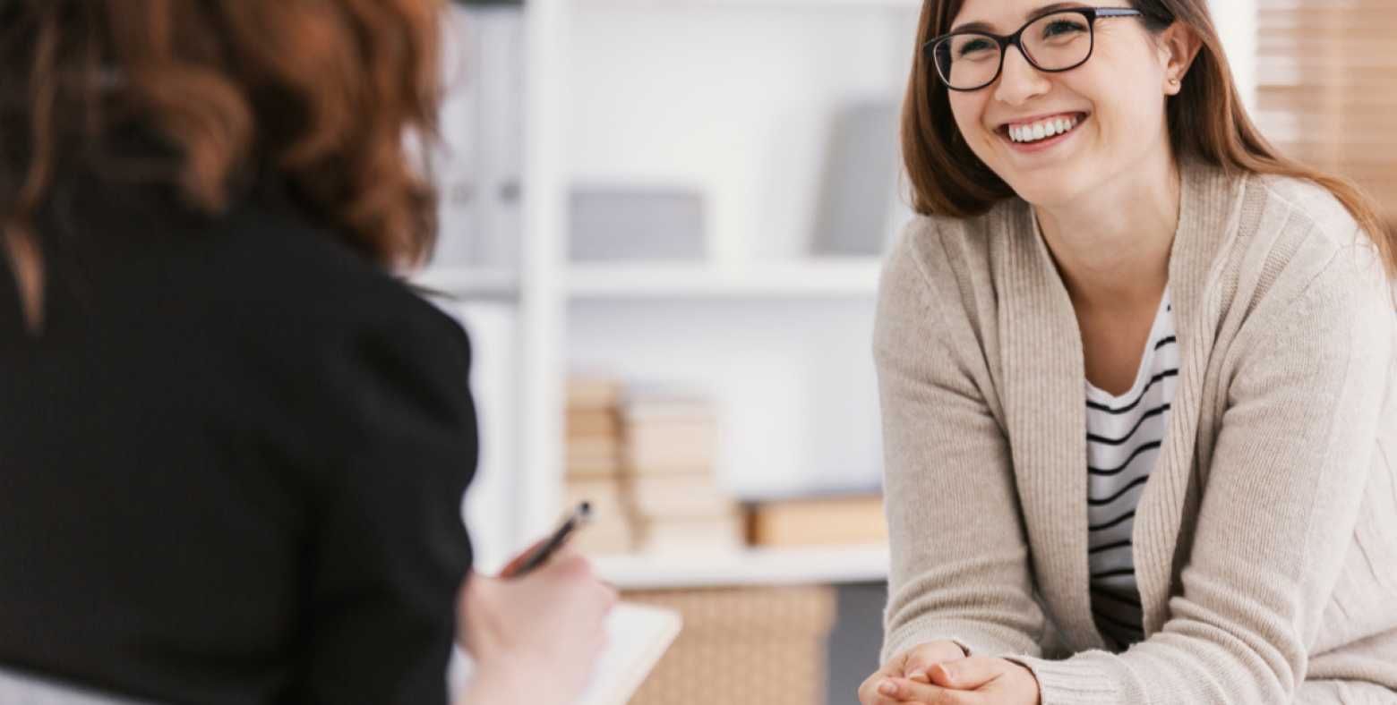 smiling female sitting in front of health practitioner