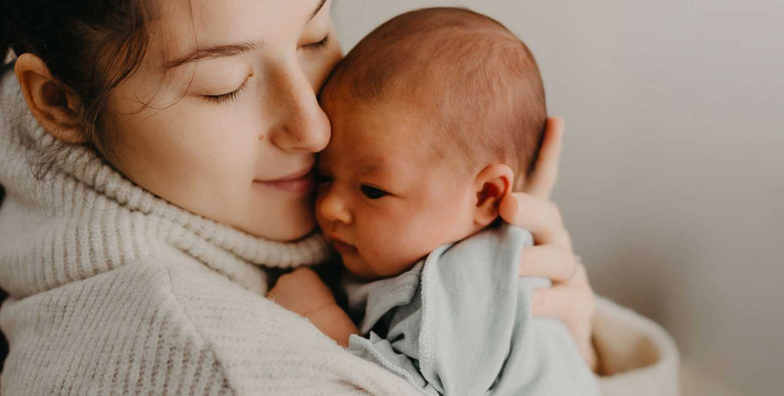 Mom cuddling sweet newborn baby