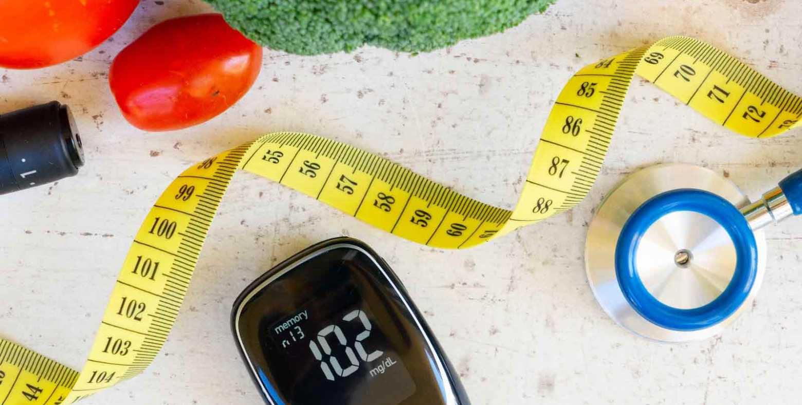 Vegetables with stethoscope, measuring tape and heart rate monitor