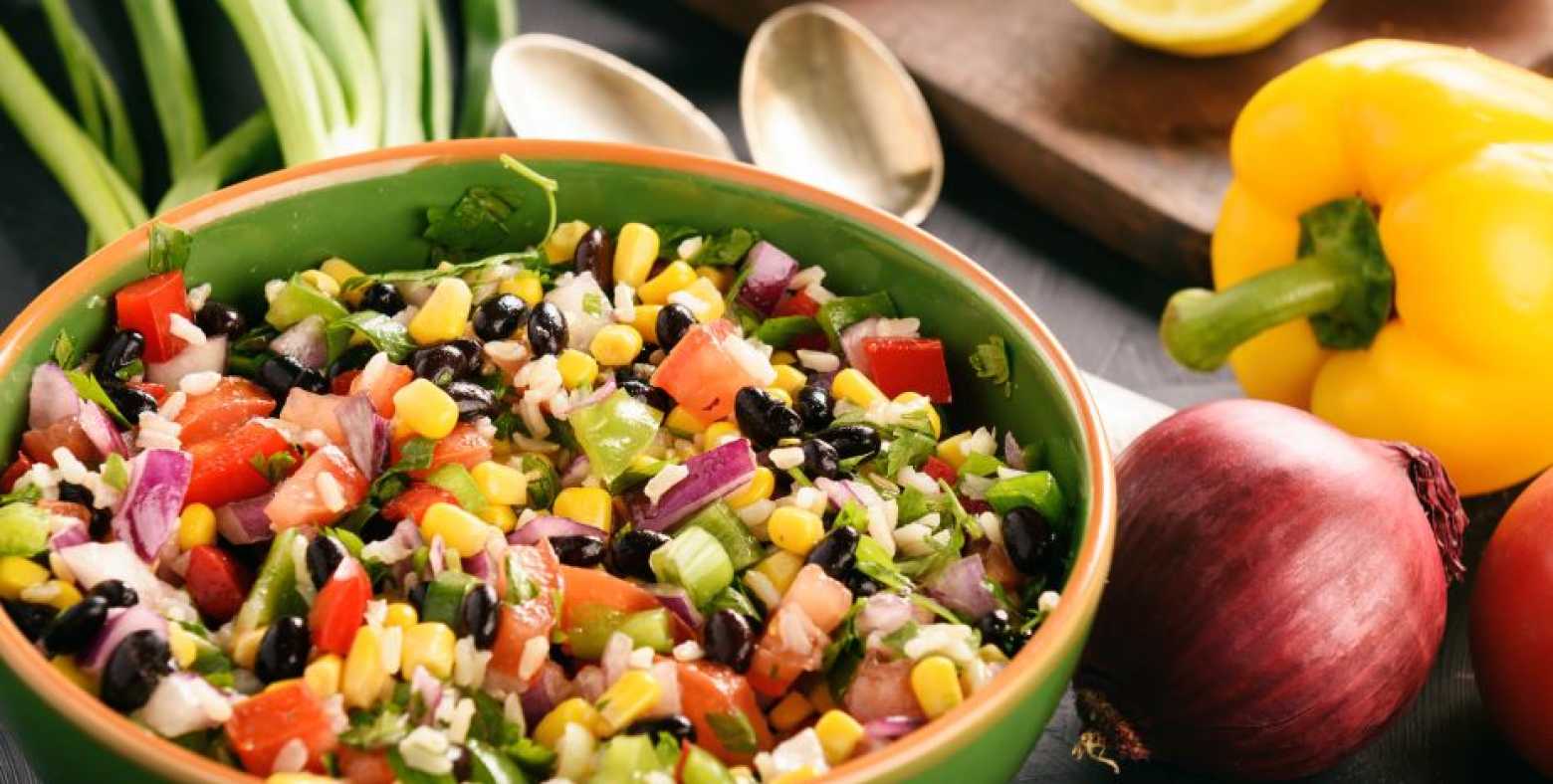 bowl of cowboy caviar with bell pepper and red onion beside bowl