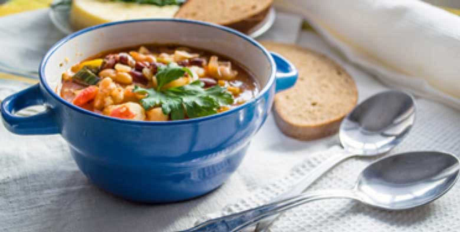 Bowl of Everything but the Kitchen Sink Formula dish with spoons and pieces of bread on the side