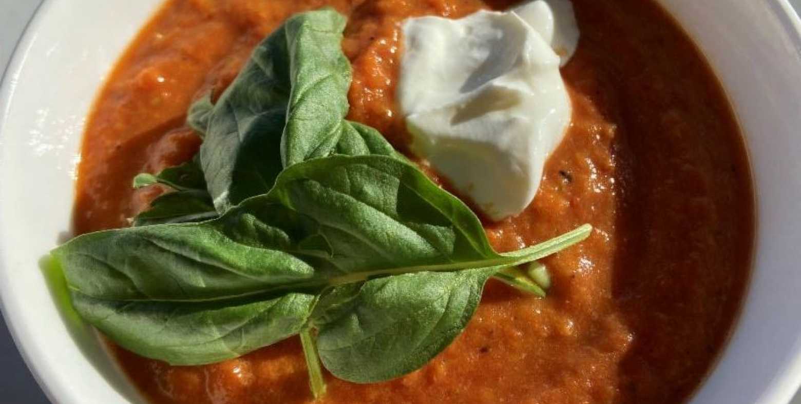 bowl of roasted red pepper and tomoto soup with fresh basil