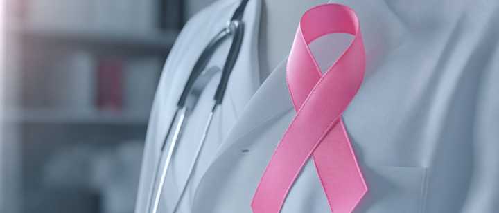 Pink ribbon on Doctor's white lab coat and stethoscope