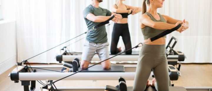 Group of people exercising on pilates reformer