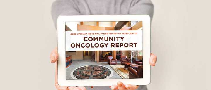 Woman holding an iPad with Community Oncology Report on the screen