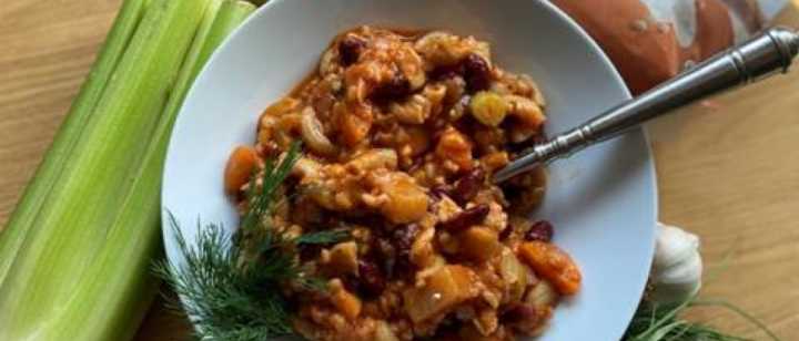 Bowl of Garden Minestrone Soup with vegetables around bowl