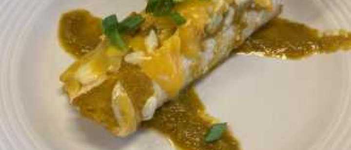 homemade tomatillo sauce over enchilada on plate