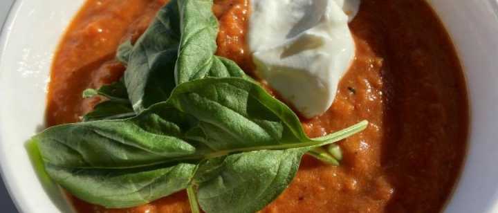 bowl of roasted red pepper and tomoto soup with fresh basil